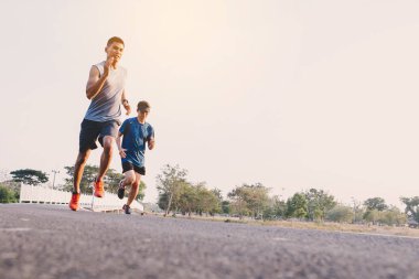 young people runner running on running road in city park