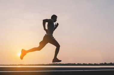şehir parkında koşu yolu üzerinde çalışan genç adam Runner