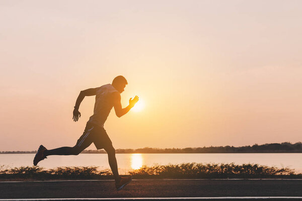 young man runner running on running road in city park