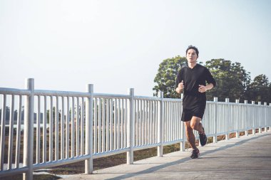 şehir parkında koşu yolu üzerinde çalışan genç adam Runner