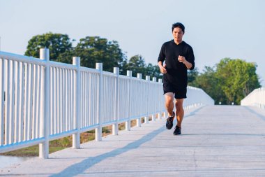 şehir parkında koşu yolu üzerinde çalışan genç adam Runner