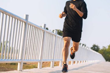 şehir parkında koşu yolu üzerinde çalışan genç adam Runner