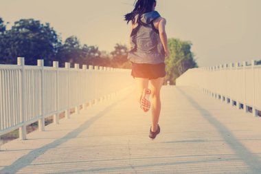 şehir parkında koşu yolu üzerinde çalışan genç kadın Runner