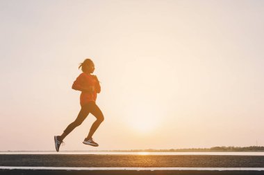 şehir parkında koşu yolu üzerinde çalışan genç kadın Runner