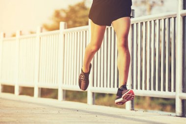 şehir parkında koşu yolu üzerinde çalışan genç kadın Runner