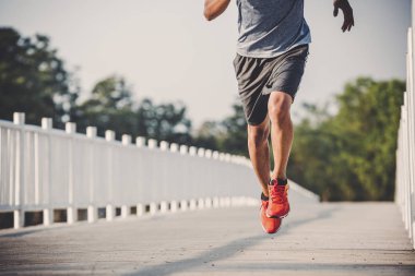 şehir parkında koşu yolu üzerinde çalışan genç adam Runner