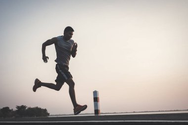 şehir parkında koşu yolu üzerinde çalışan genç adam Runner