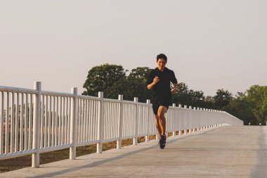 şehir parkında koşu yolu üzerinde çalışan genç adam Runner