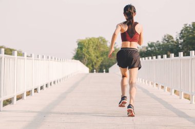 şehir parkında koşu yolu üzerinde çalışan genç kadın Runner