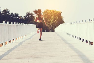 şehir parkında koşu yolu üzerinde çalışan genç kadın Runner