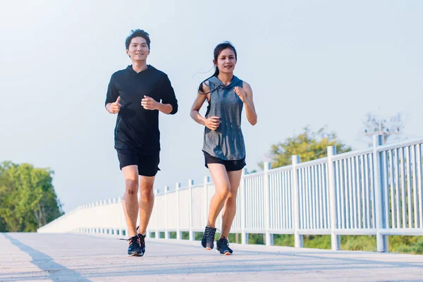 Joven pareja corredor corriendo en running carretera en ciudad parque —  Fotos de Stock