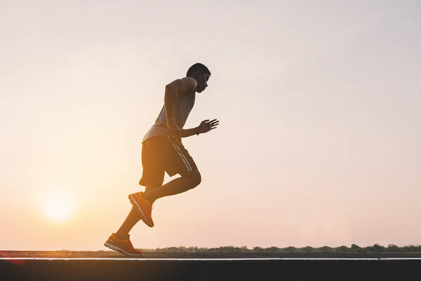 young man runner running on running road in city park