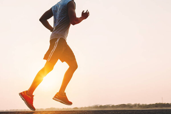 young man runner running on running road in city park