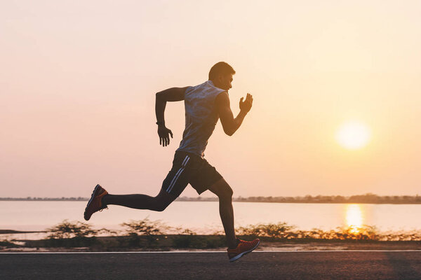 young man runner running on running road in city park