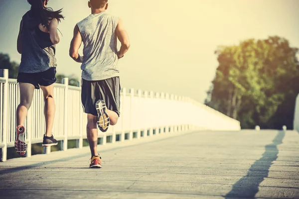 Joven pareja corredor corriendo en running carretera en ciudad parque — Foto de Stock