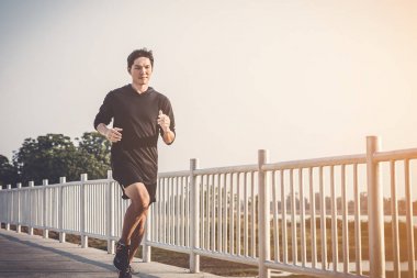 şehir parkında koşu yolu üzerinde çalışan genç adam Runner