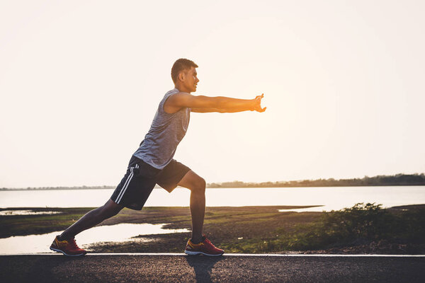 young man runner running on running road in city park