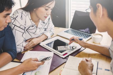 İş adamları bir projeyi tartışır; Hesaplamanda oturan bir kadın