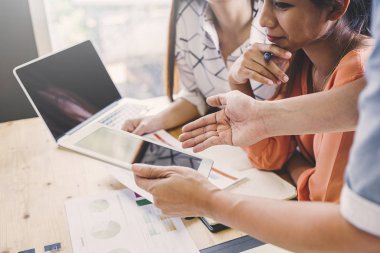 İş adamları bir projeyi tartışır; Hesaplamanda oturan bir kadın