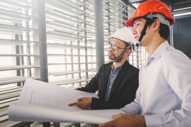 Danışman mühendis planda inşaat projesini tartışıyor
