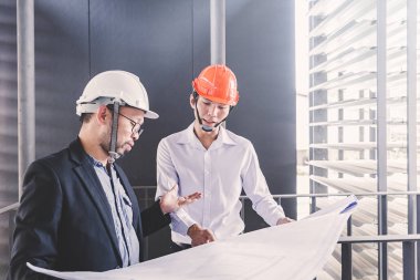 Danışman mühendis planda inşaat projesini tartışıyor