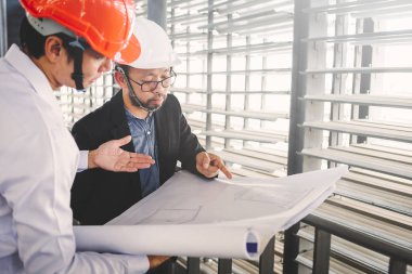 Danışman mühendis planda inşaat projesini tartışıyor