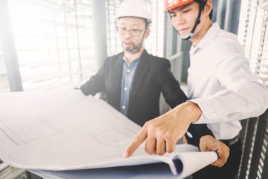 Danışman mühendis planda inşaat projesini tartışıyor