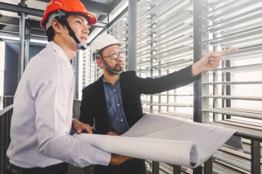 Danışman mühendis planda inşaat projesini tartışıyor