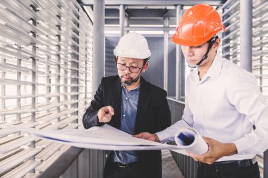 Danışman mühendis planda inşaat projesini tartışıyor