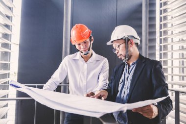 Danışman mühendis planda inşaat projesini tartışıyor