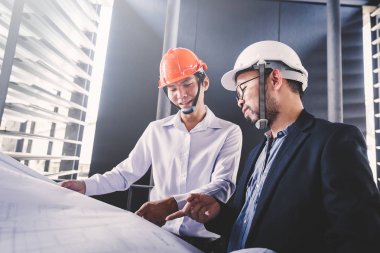 Danışman mühendis planda inşaat projesini tartışıyor