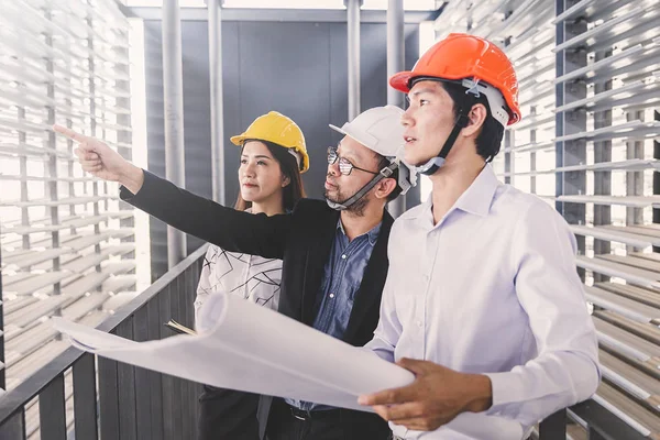 Danışman mühendis planda inşaat projesini tartışıyor