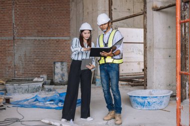 İnşaat alanında çalışan mühendis, mühendis ve teknisyen, inşaat şantiyesi mühendisi proje planı üzerinde çalışıyor ve denetliyor