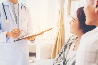 Hastanede, tıpta, hamilelikte, sağlık hizmetlerinde ve jinekoloji konseptinde hamile kadın ailesi olan bir doktor. 