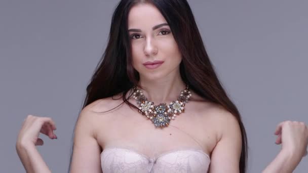 Hermosa mujer posando en el estudio. Ella muestra joyas de mujer — Vídeos de Stock