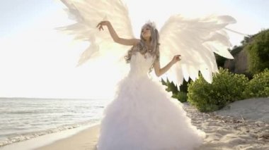 Hassas güzel sarışın kadın melek kanatları sahil ile poz