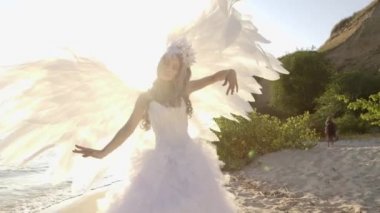 Hassas güzel sarışın kadın melek kanatları sahil ile poz