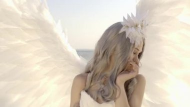 Hassas güzel sarışın kadın melek kanatları sahil ile poz