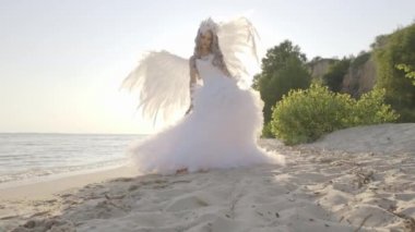 Hassas güzel sarışın kadın melek kanatları sahil ile poz