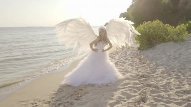 Hassas güzel sarışın kadın melek kanatları sahil ile poz