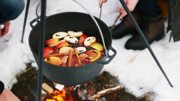 Gotowania grzane wino na ognisku w lesie zimą. — Wideo stockowe