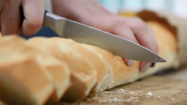 Femme coupe du pain blanc sur planche à découper en bois, mains gros plan . — Video