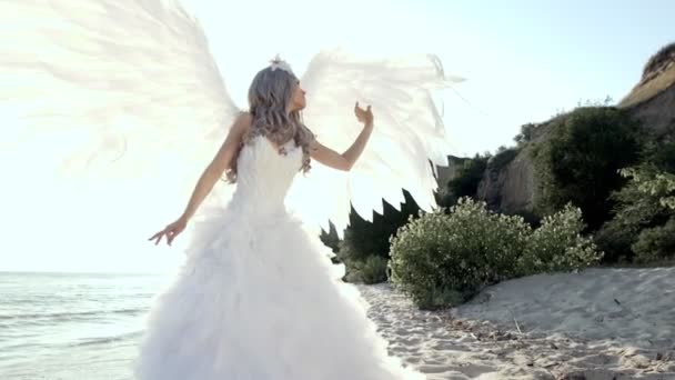 Delikatne piękne blond kobieta stwarzających z angel wings pobrzeże — Wideo stockowe