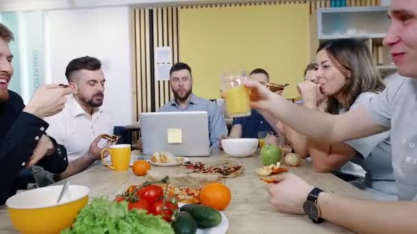 Office lunch. Personalen demonteras pizza från tabellen. Lunchrast på jobbet. — Stockvideo