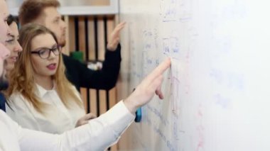 Ofiste beyin fırtınası. Meslektaşları sorun tartışmak ve bir beyaz tahta üzerine notlar.