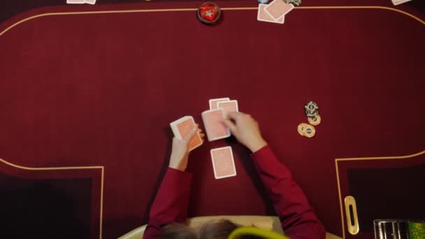 Казино дилер положить карты на красный стол, покер, азартные игры, крупным планом руки. Вид сверху . — стоковое видео