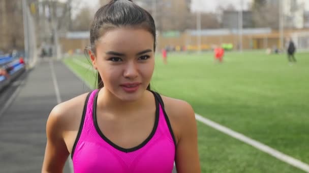 Αθλητική ασιατικό κορίτσι τρέχει στο γήπεδο. Γυμναστήριο, έννοιας σπορ. — Αρχείο Βίντεο