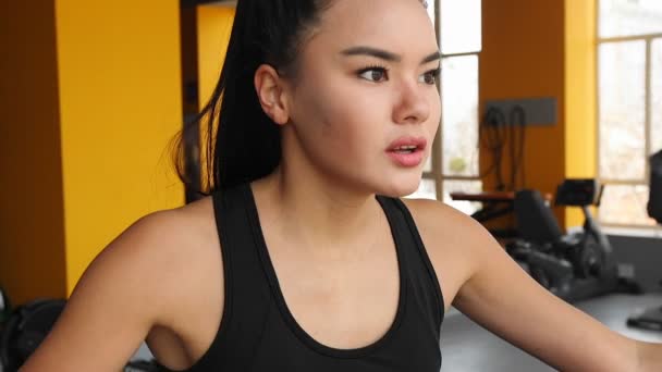 Giovane ragazza asiatica che fa sport sul trainer ellittica in palestra . — Video Stock