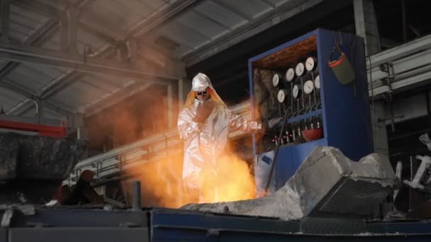 Mężczyzna pracujący w fabryce w płynnym metalem. Fabryka metalowych iskier — Wideo stockowe