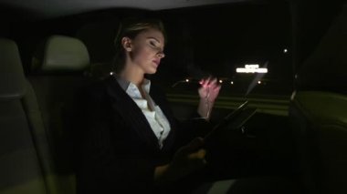 Yorgun işkadını telefonda konuşurken arabada. Gece yolda arabaya biniyor.